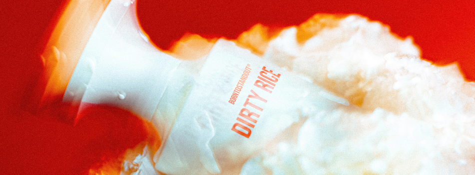 Werbebanner mit verschwommenem Parfumflakon der Marke Borntostandout, Aufdruck „Dirty Rice“ in roter Schrift vor leuchtend rotem Hintergrund mit weißen und orangen Farbverläufen.