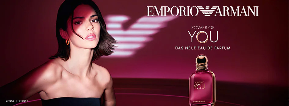 Werbebanner für Emporio Armani Power of You Eau de Parfum: Eine elegant gestylte Frau mit dunklem, kurzem Haar vor bordeauxrotem Hintergrund. Rechts steht der rosafarbene Parfumflakon mit goldener Verschlusskappe. Darüber der Schriftzug „Emporio Armani – Power of You, das neue Eau de Parfum“.