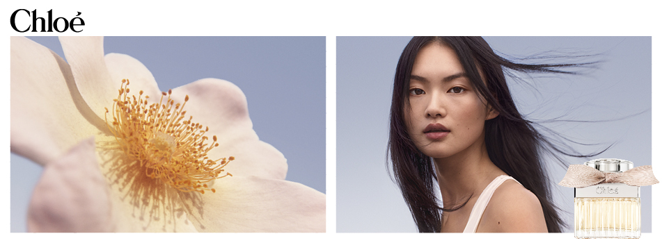 Nahaufnahme einer zarten, cremefarbenen Blüte neben dem Porträt einer Frau mit dunklem Haar vor blauem Himmel. Unten rechts ist ein Chloé Parfumflakon mit beigefarbener Schleife zu sehen.