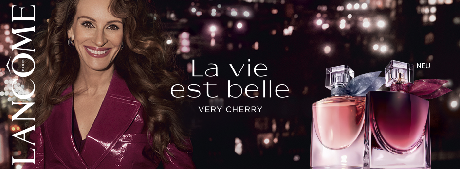 Lancôme La Vie Est Belle Very Cherry Markenbild mit Parfum-Flakons vor nächtlicher Stadtkulisse